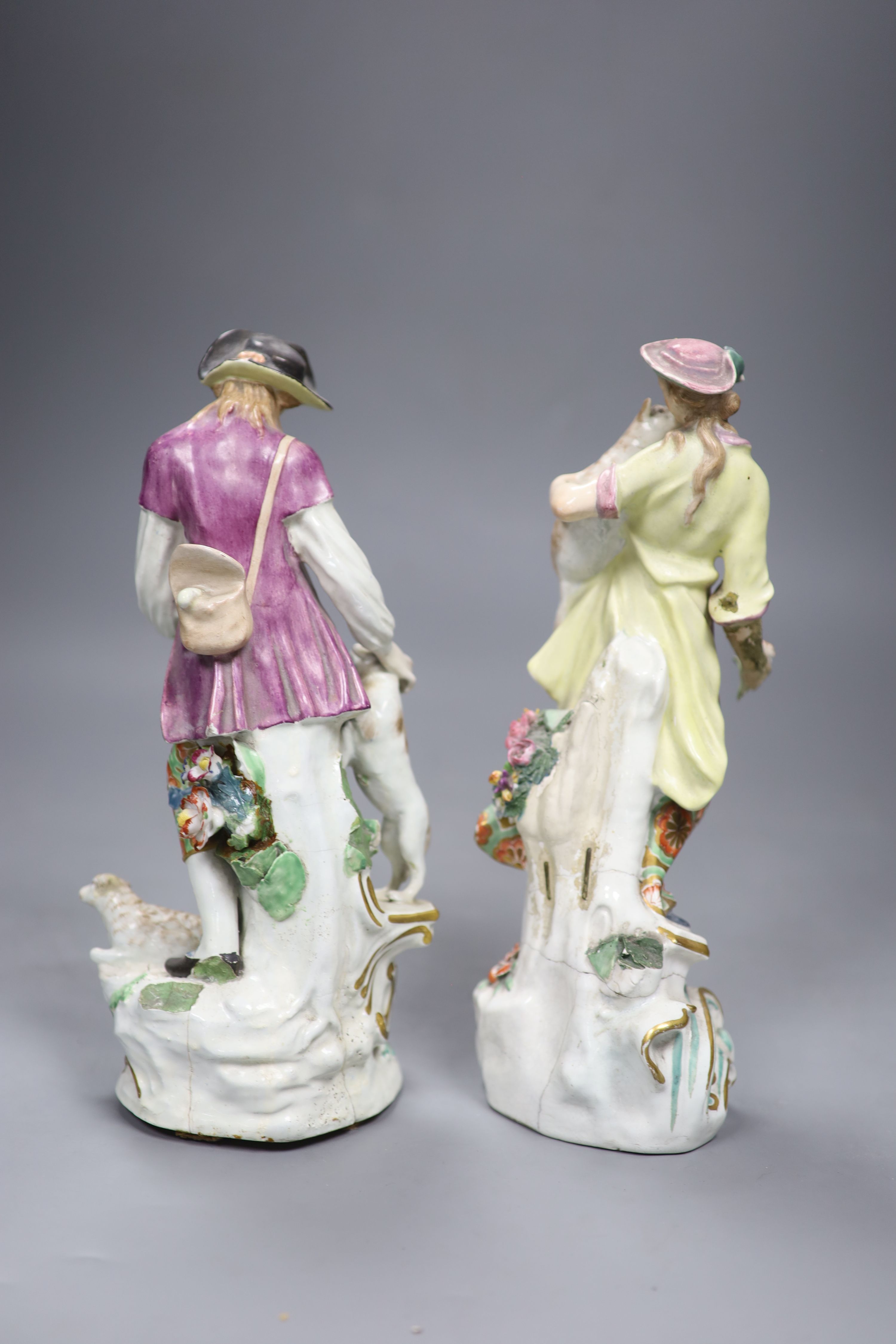 A pair of 18th century English Chelsea Derby figures of a boy and girl holding animals, height 25cm